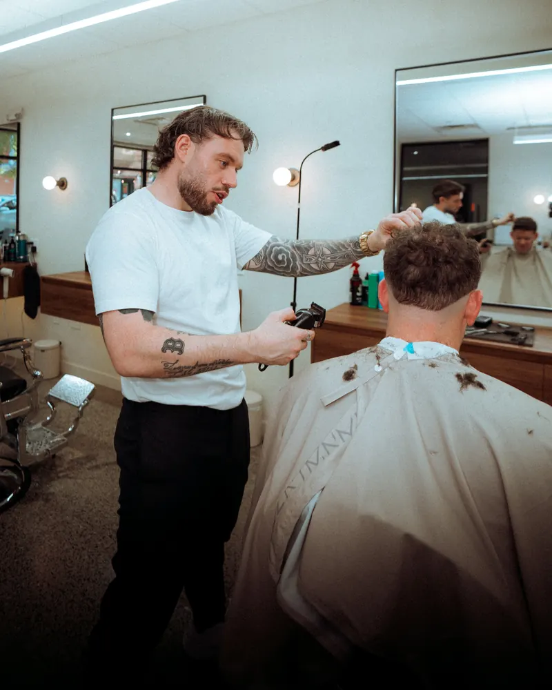 A barber checking the length before taking the clippers to it